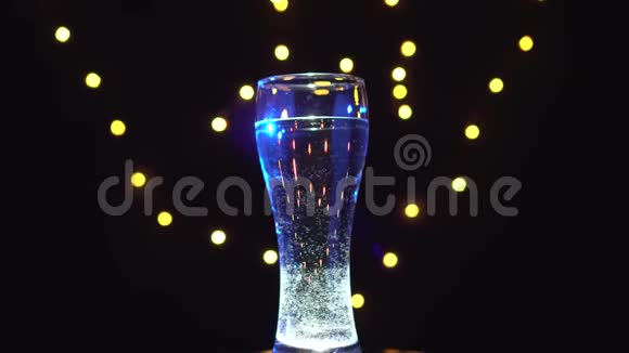 一杯蓝色的水在旋转蓝色鸡尾酒酒吧概念视频的预览图