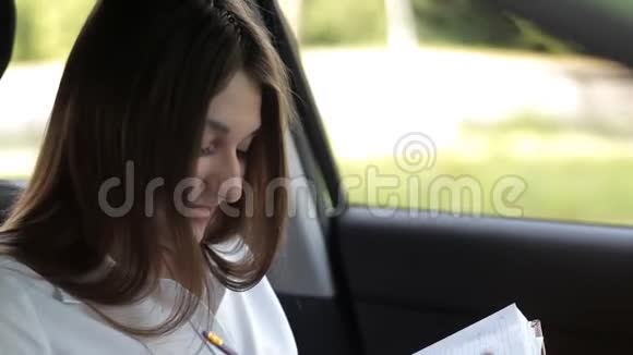 女商人在车里把工作记录在笔记本上视频的预览图