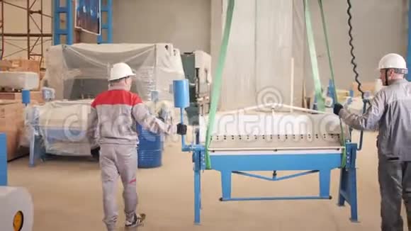 制造车间工人在仓库里用起重机工作生产通风和排水沟工具视频的预览图