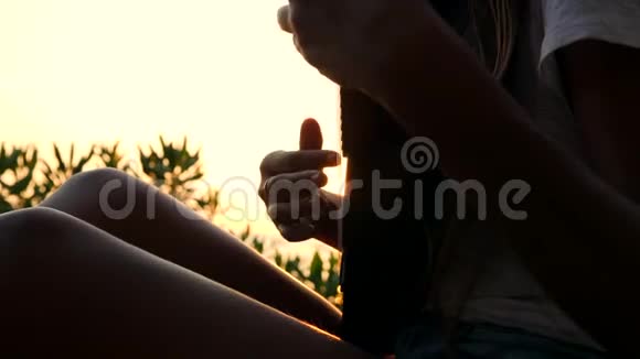 年轻的希普斯特女人在美丽的热带海滩日落时演奏尤库勒吉他4K泰国视频的预览图