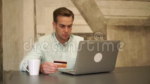 网上银行那个人坐在桌子旁拿着信用卡视频的预览图