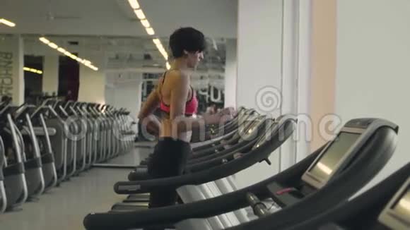 白种人女人在跑步机上跑步视频的预览图