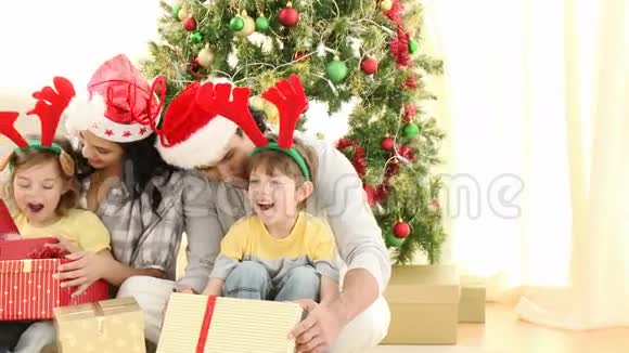 家长和孩子在家中打开圣诞礼物视频的预览图