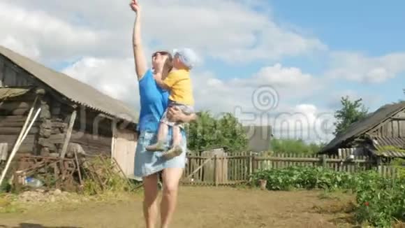 夏天一位带着婴儿的年轻母亲在绿色的田野里放风筝妈妈做得不好儿子很高兴视频的预览图