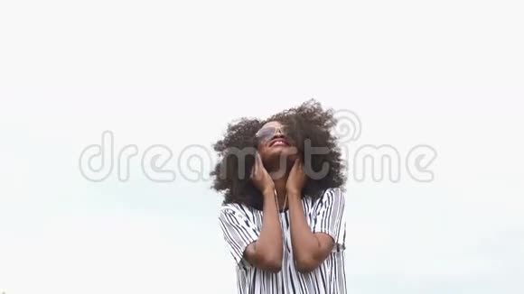年轻时尚的非裔美国年轻女性戴着太阳镜听音乐微笑欢乐和幸福的时刻视频的预览图