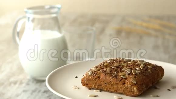美味的自制小面包和种子牛奶罐在木制的乡村餐桌上失踪了视频的预览图