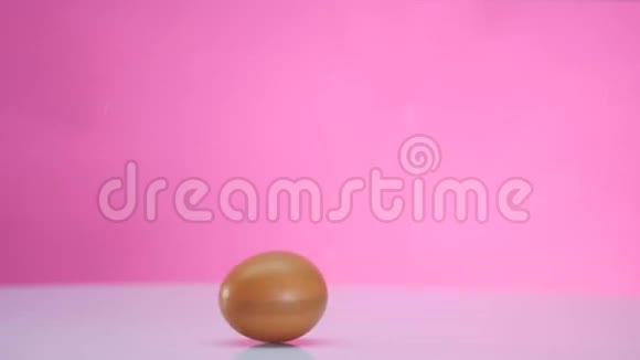 鸡蛋在粉红色背景的桌子上旋转视频的预览图