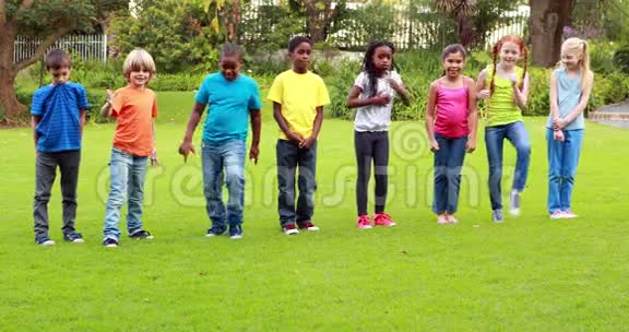 一群可爱的小学生在草地上奔跑视频的预览图