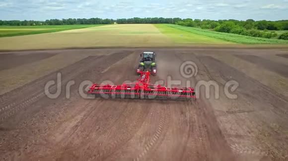 农用拖拉机有拖车在农田上犁农业部门视频的预览图