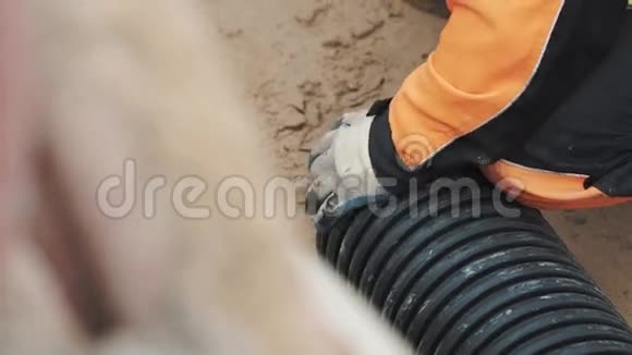 工人工作手套胶靴拉沙出黑色塑料管视频的预览图
