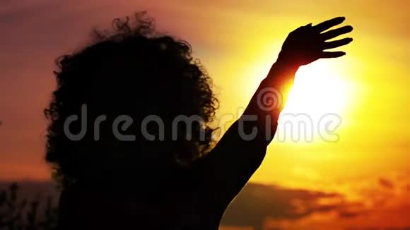 女人在日落时挥手视频的预览图