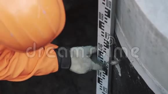 橙色安全帽的工人用长长的工业金属尺子制作珠宝视频的预览图