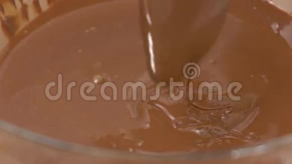 将融化的巧克力放入一个玻璃碗中搅拌视频的预览图