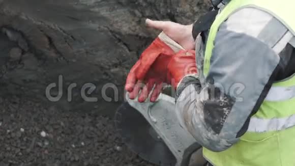 工人在沟里用圆锯戴上红色橡胶手套慢动作视频的预览图