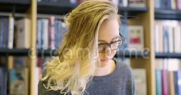 在学校图书馆工作的带眼镜的女学生视频的预览图
