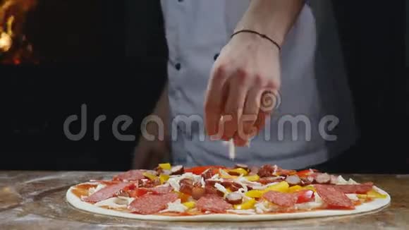 跟踪特写镜头将未烘烤的披萨和面粉桌上的配料放在金属皮上视频的预览图