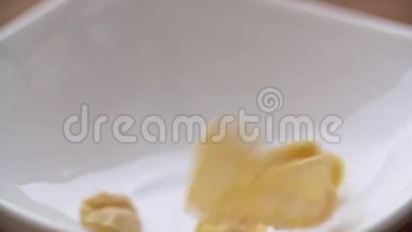 玉米片缓慢地落在白色的碗里近景视频的预览图