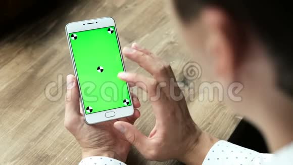 男士使用带有绿色屏幕显示的手机视频的预览图