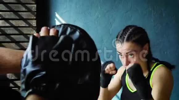 特写适合白人女拳击手训练与拳击教练在健身房视频的预览图