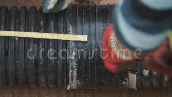 工人手戴手套用卷尺测量黑色塑料管视频的预览图
