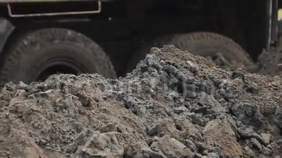 慢动挖掘机斗在建筑工地附近挖掘泥土和泥土视频的预览图
