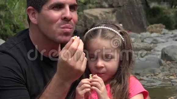 父亲女儿在河边吃零食视频的预览图