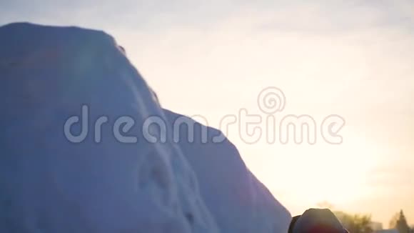 孩子在雪山上玩耍要爬到山顶日落时分视频的预览图