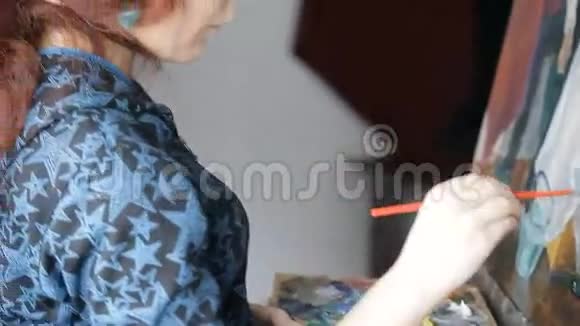 画架上画着红色头发的女画家视频的预览图