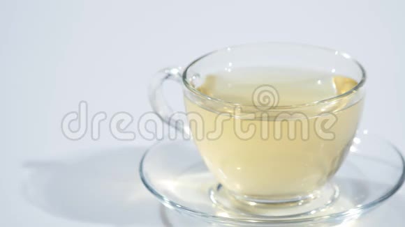 在一个装有红茶的茶托上的杯子里一片柠檬倒在白色的背景上慢着视频的预览图