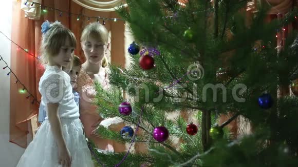 一家人看着圣诞树上的花环视频的预览图