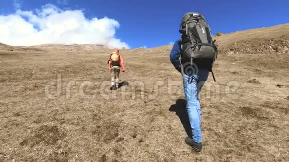 两个戴着帽子和太阳镜背包的游客摄影师带着相机在黄草上山视频的预览图