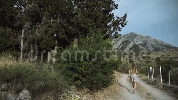 带着摄像机走的女游客白色房屋的美丽景色年轻的女摄影师戴着太阳帽视频的预览图