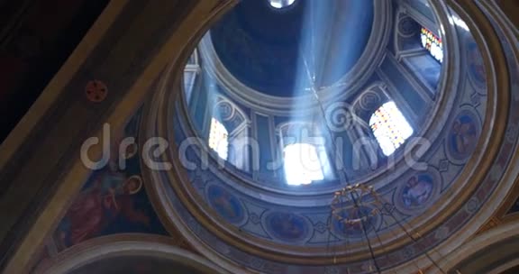 阳光透过教堂的老玻璃窗照射进来室内用吊灯照明视频的预览图
