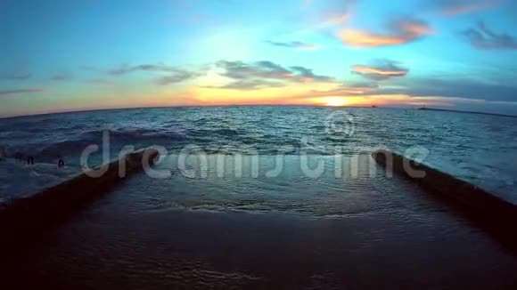 冬天的海浪拍打着码头蓝天和日落视频的预览图