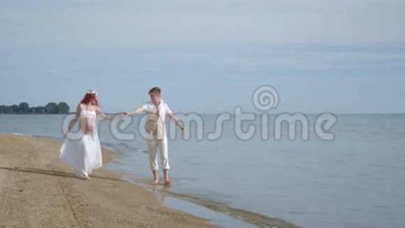 一对散步海滩在海边怀孕的夫妇海滩上的孕妇视频的预览图