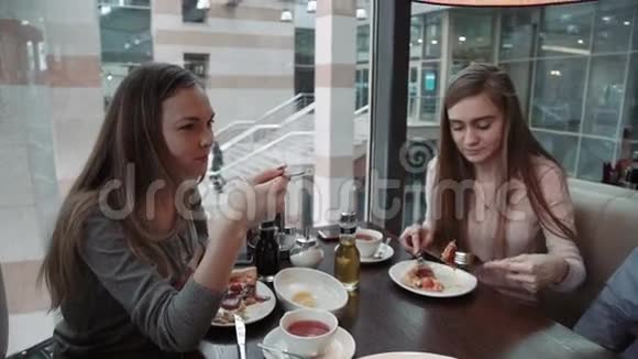 朋友两个年轻的女人在咖啡馆见面商务午餐聊天吃意大利披萨视频的预览图