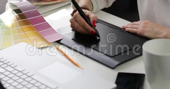 女性平面设计师使用数码绘图平板电脑办公视频的预览图