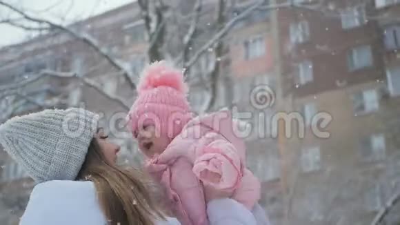年轻的母女在公园的大雪中幸福地在一起视频的预览图