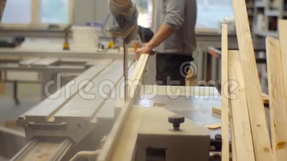 木工车间的工人在机器上锯木板视频的预览图