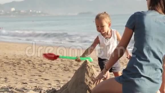 妈妈和她的小女儿在沙滩上玩水视频的预览图