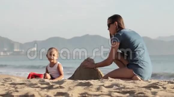 妈妈和她的小女儿在沙滩上玩水视频的预览图