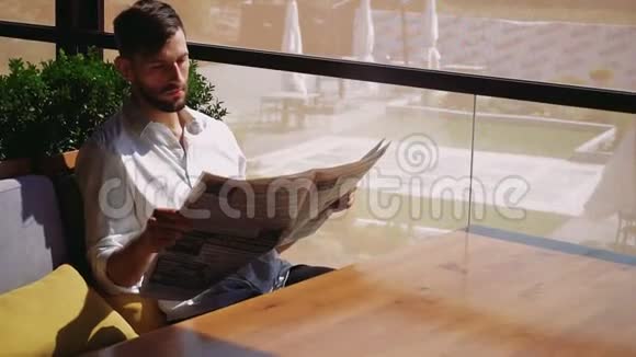 英俊的男人看报纸好奇视频的预览图
