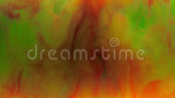 五颜六色的红黄墨水混合在水中柔和地在水下旋转背景上有绿色墨水视频的预览图