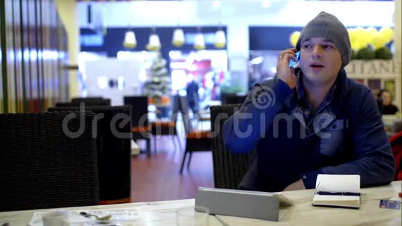 咖啡馆里的年轻人在打电话视频的预览图
