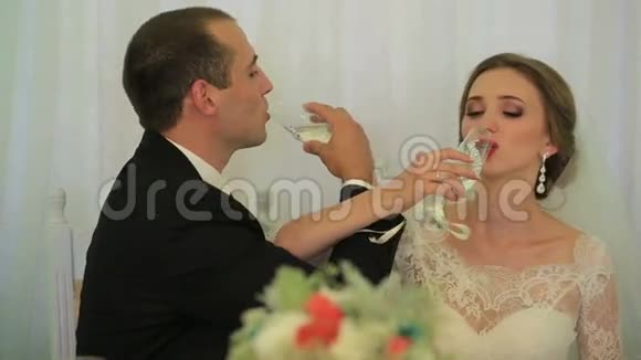美丽的年轻夫妇迷人的新娘和可爱的新郎结婚后喝香槟视频的预览图