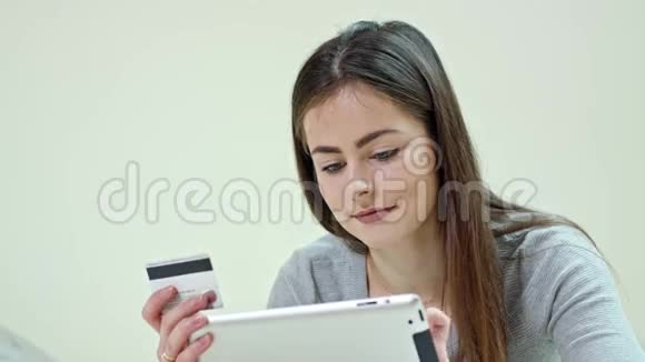 使用数码平板电脑躺在家里的女人视频的预览图