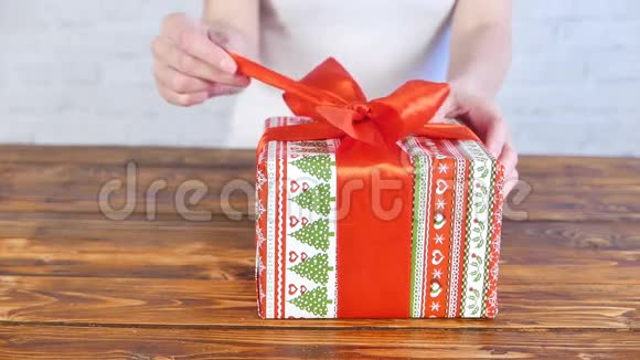 女孩用红色丝带打开礼物盒视频的预览图