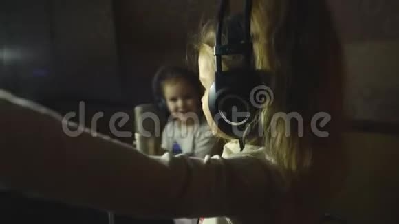 两个戴着耳机的小女孩拿着麦克风唱歌视频的预览图
