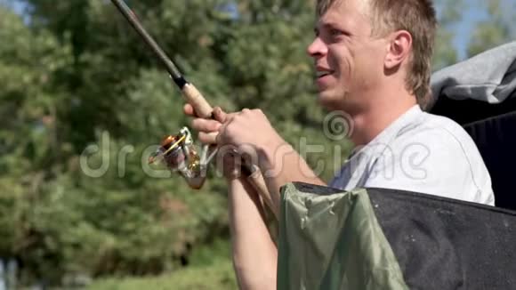渔人在咬鱼时钓鱼并旋转鱼卷视频的预览图
