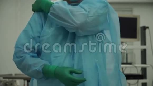 男外科医生在手术后摘下手套和长袍视频的预览图